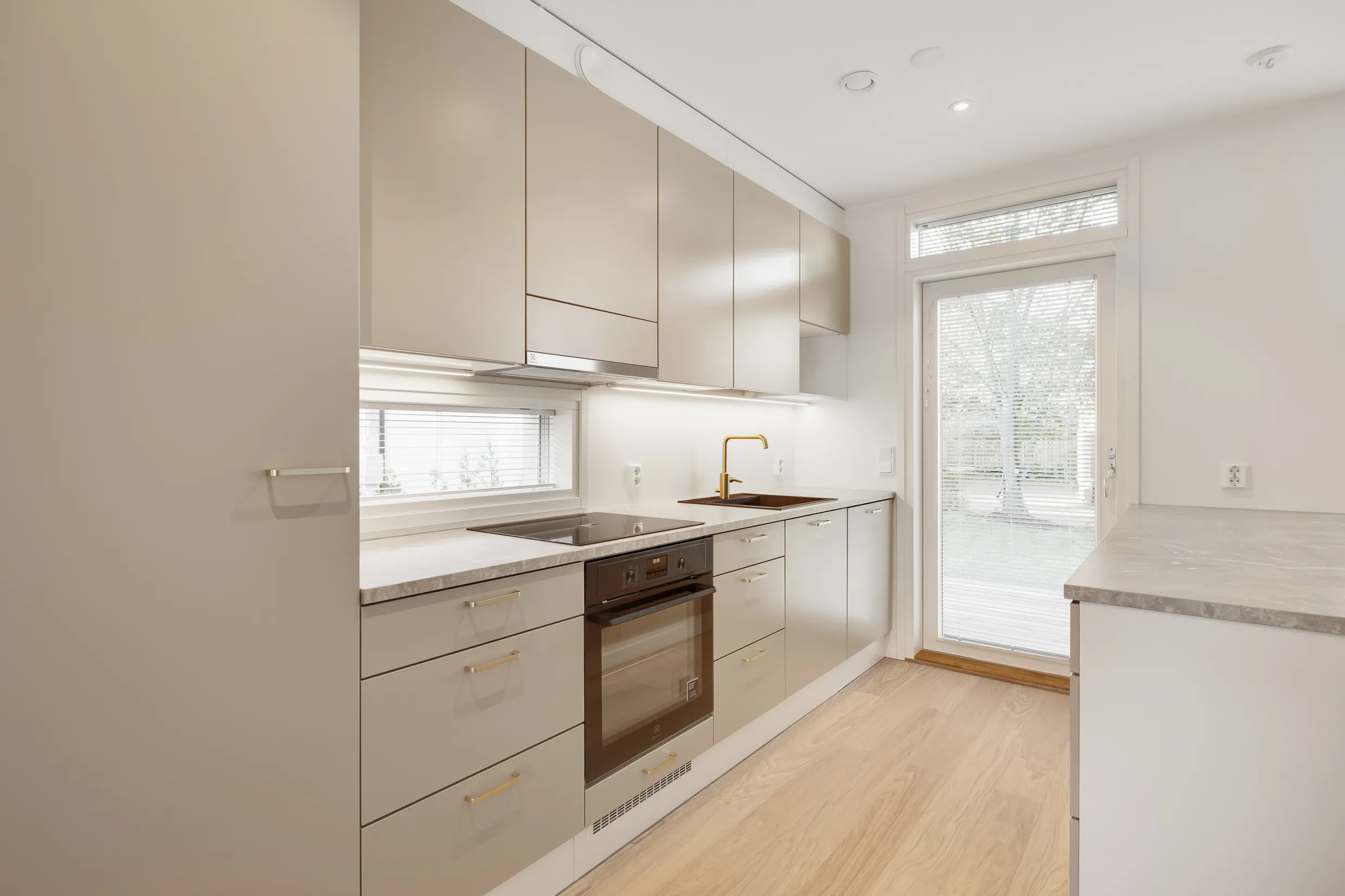 Vaalean keittiön sisustus, jossa on puulattia ja ikkuna.